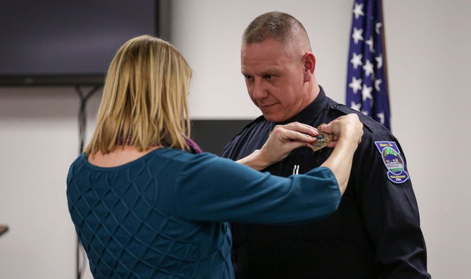 Mason City Police Chief Jeff Brinkley's wife Lisa, pins his badge on during the swearing in ceremony.(AARON THOMAS / Globe Gazette)